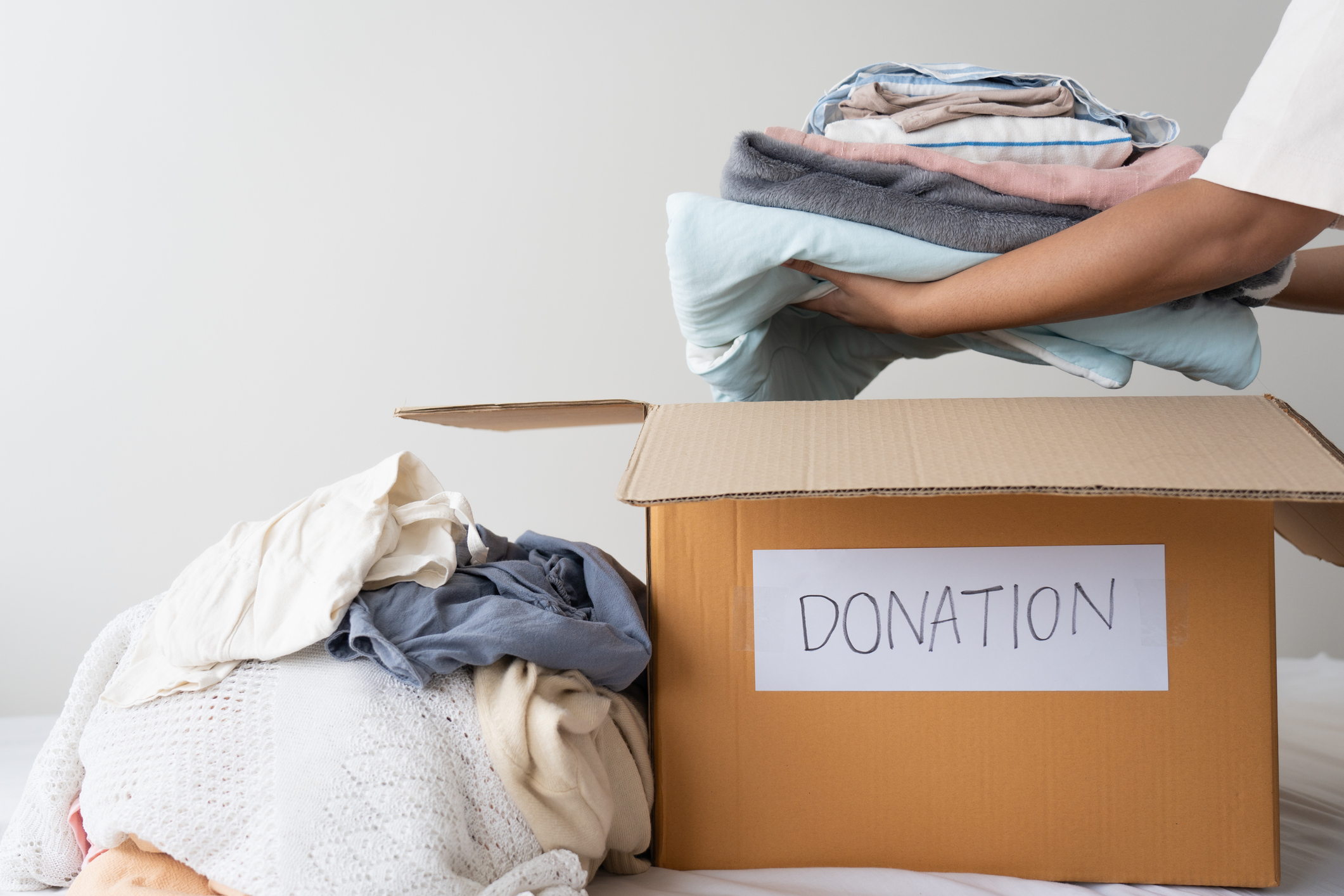 Woman hands holding clothes putting in a donation box. Sharing, Help, Donation concept