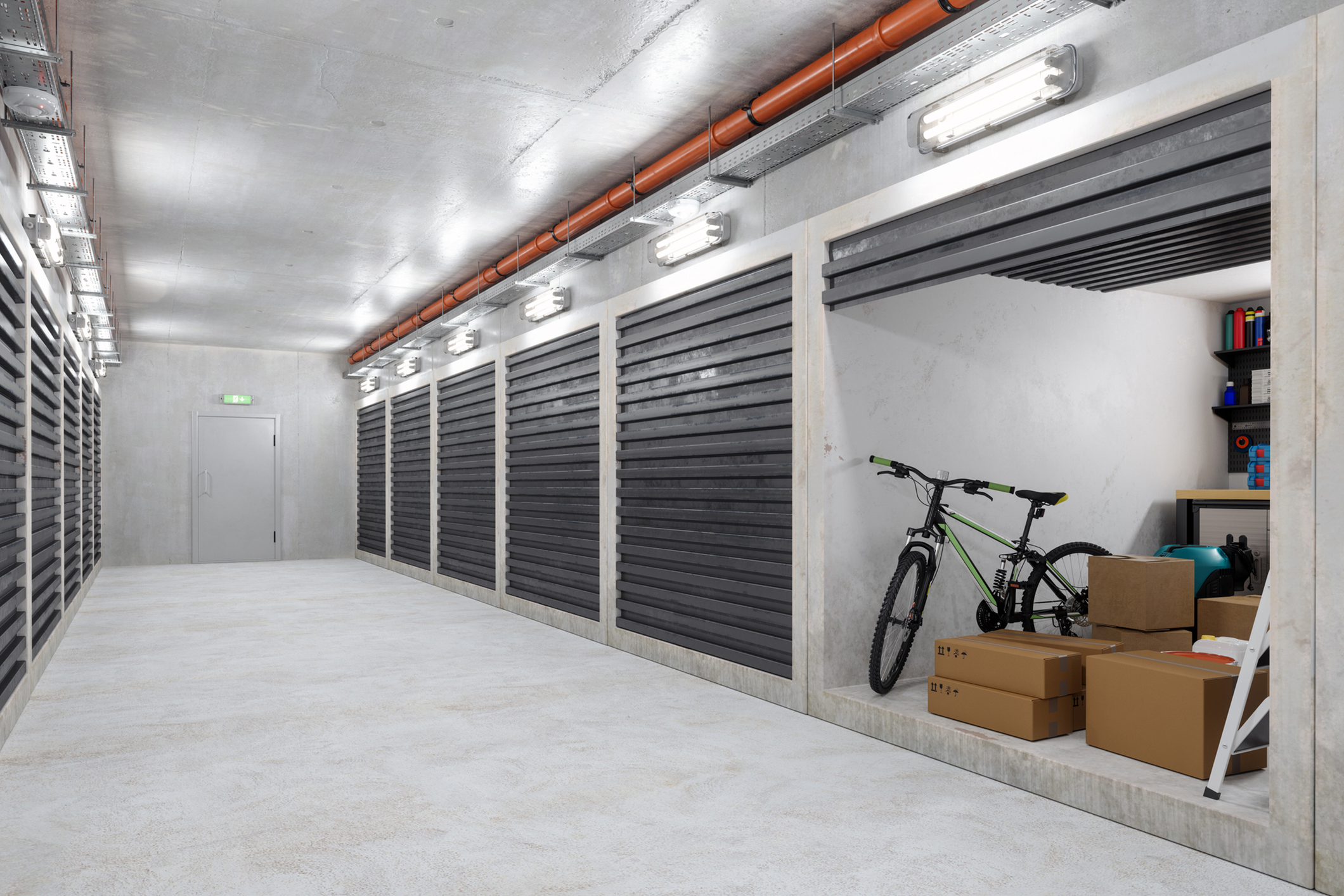Self Storage Warehouse Building. Empty Corridor With Self Storage Units. Cardboard Boxes, Bicycle And Other Equipments In Open Unit